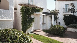 A white building with a tiled roof, a small porch, and a sign reading 'ACUARIO'. - Apartamentos Ona Club Bena Vista (Estepona)