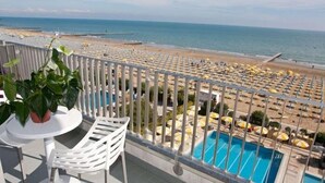 A balcony with a view of a beach and a swimming pool. - Hotel Sirenetta (Jesolo)
