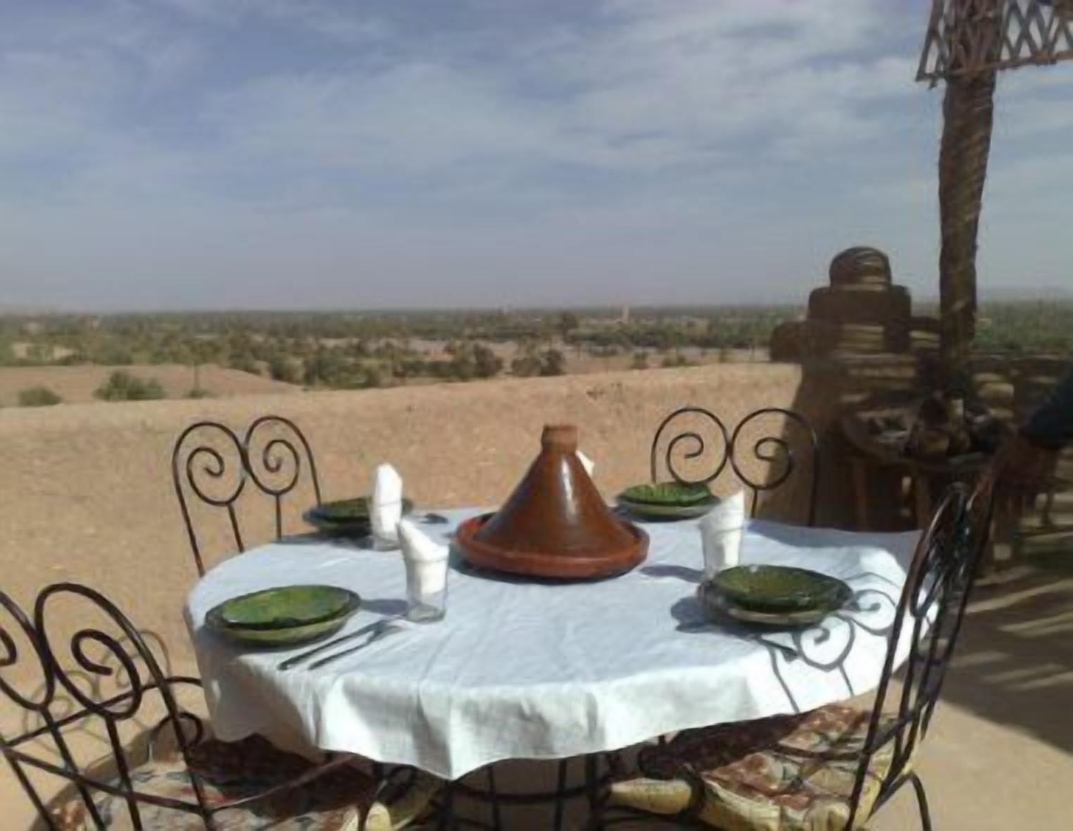 Mesa de comedor al aire libre con vista a un paisaje desértico.