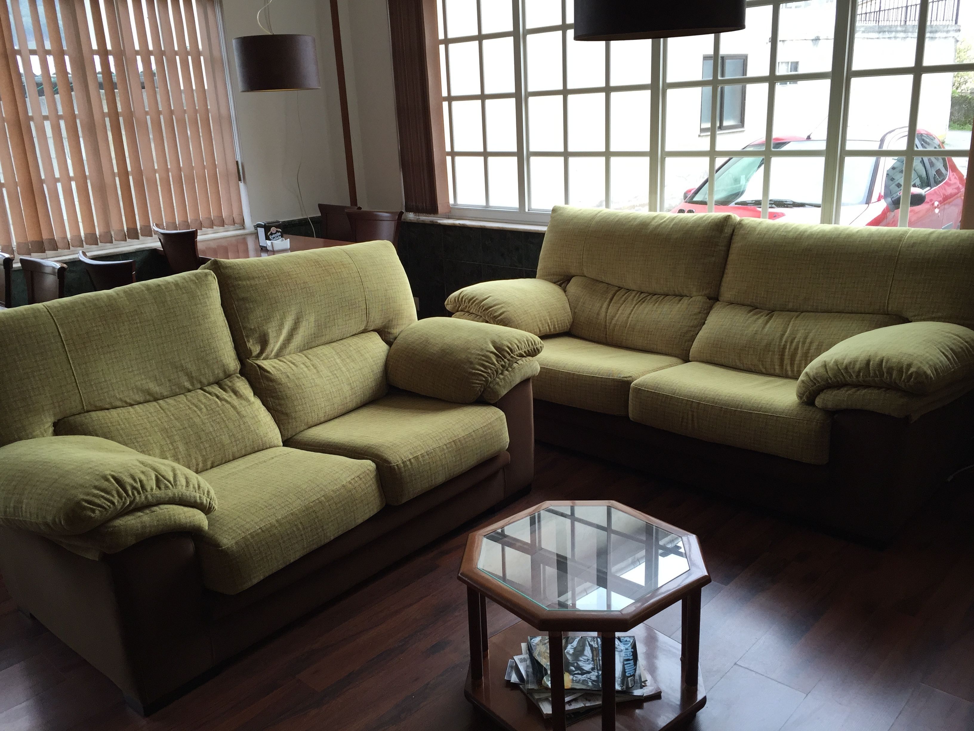Ein Wohnzimmer mit zwei Sofas und einem Glastisch.