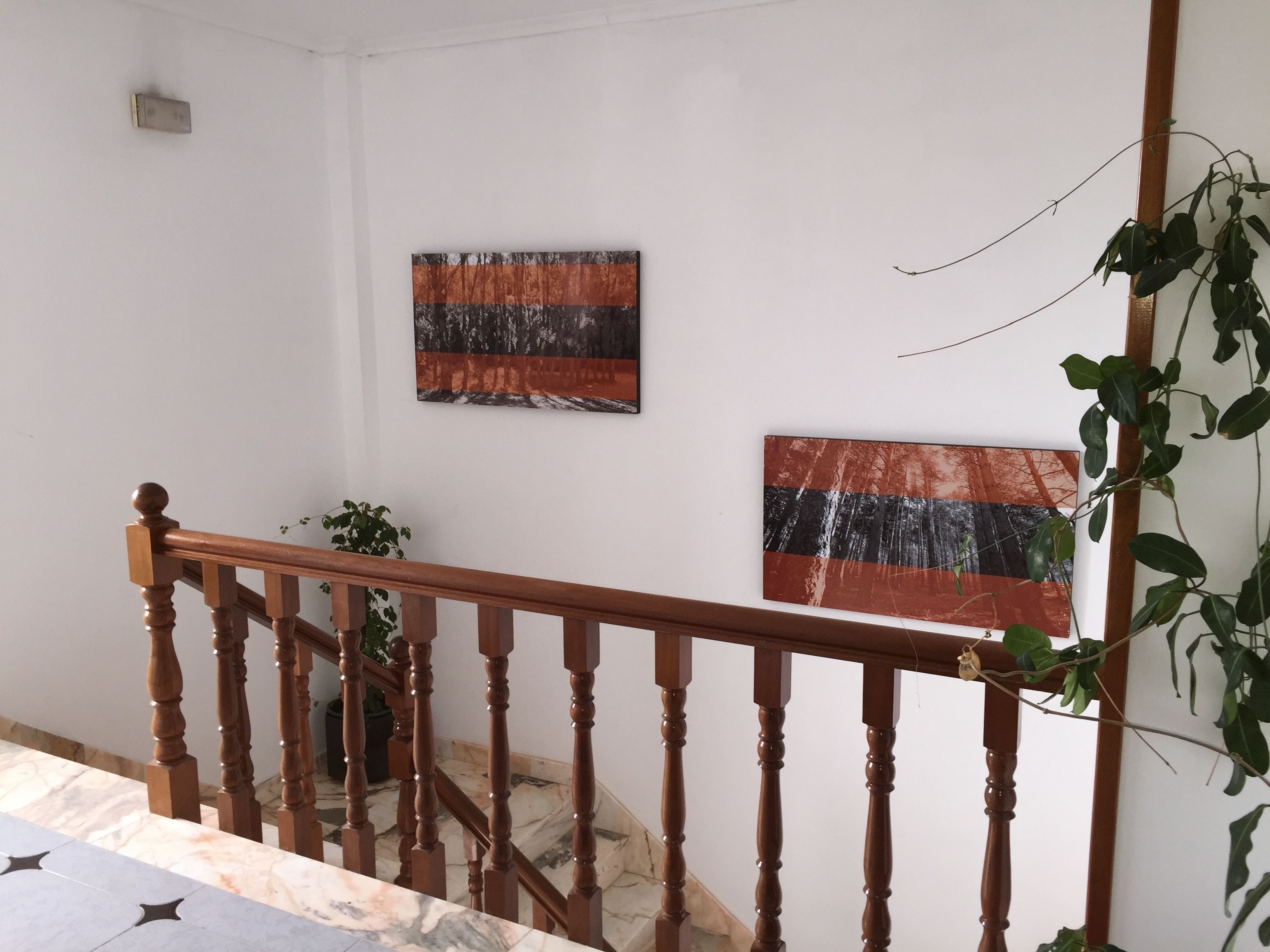A staircase with wooden balusters and a marble floor.