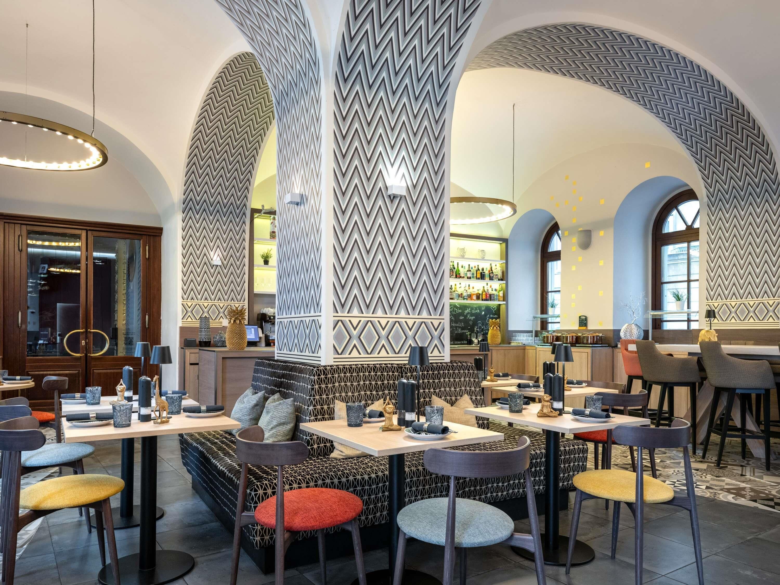 Un restaurante con techos altos en arco, paredes con diseños y una zona de bar.