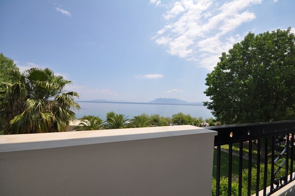 A balcony with a view of a body of water and distant mountains.