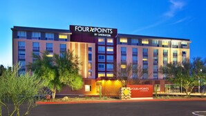 A Four Points by Sheraton hotel with a modern facade, multiple floors, and a well-lit entrance.
