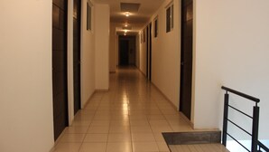 A long, narrow hallway with tiled floors and doors on both sides. - Hotel Ross Morelia (Morelia)