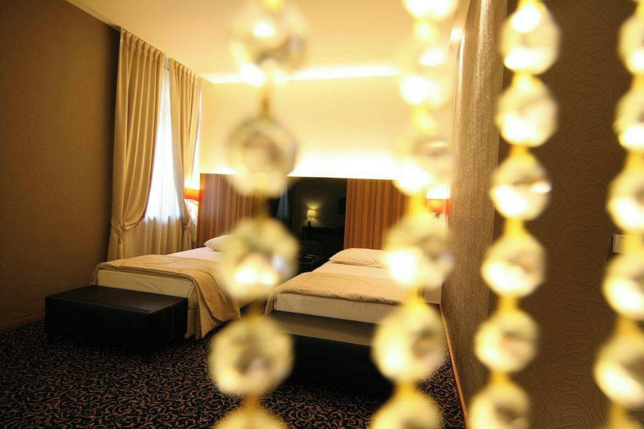A hotel room with two beds, a desk, and a chair.