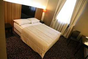 A hotel room with a bed, a desk, and a chair. - Hotel Crystal (Sarajevo)