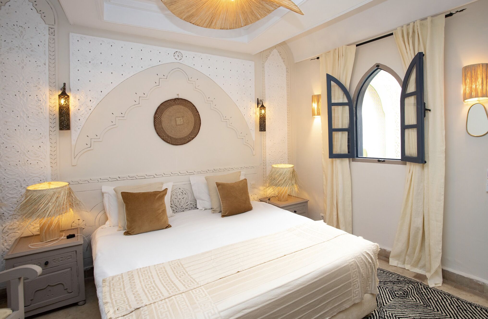Une chambre à coucher avec un grand lit, des panneaux muraux décoratifs et deux lampes de chevet.