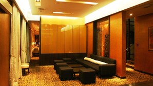 Un moderno vestíbulo de hotel con zona de estar, una escalera y vistas al comedor.