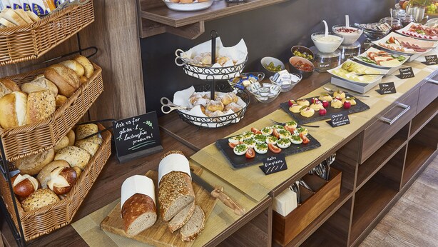 A buffet with various breads, pastries, and a selection of cheeses and meats. - Empress Hotel (Munich)