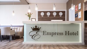 A reception desk with a glass front and the name "Empress Hotel" displayed. - Empress Hotel (Munich)