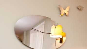 Un miroir reflétant une pièce avec une lampe et une porte.