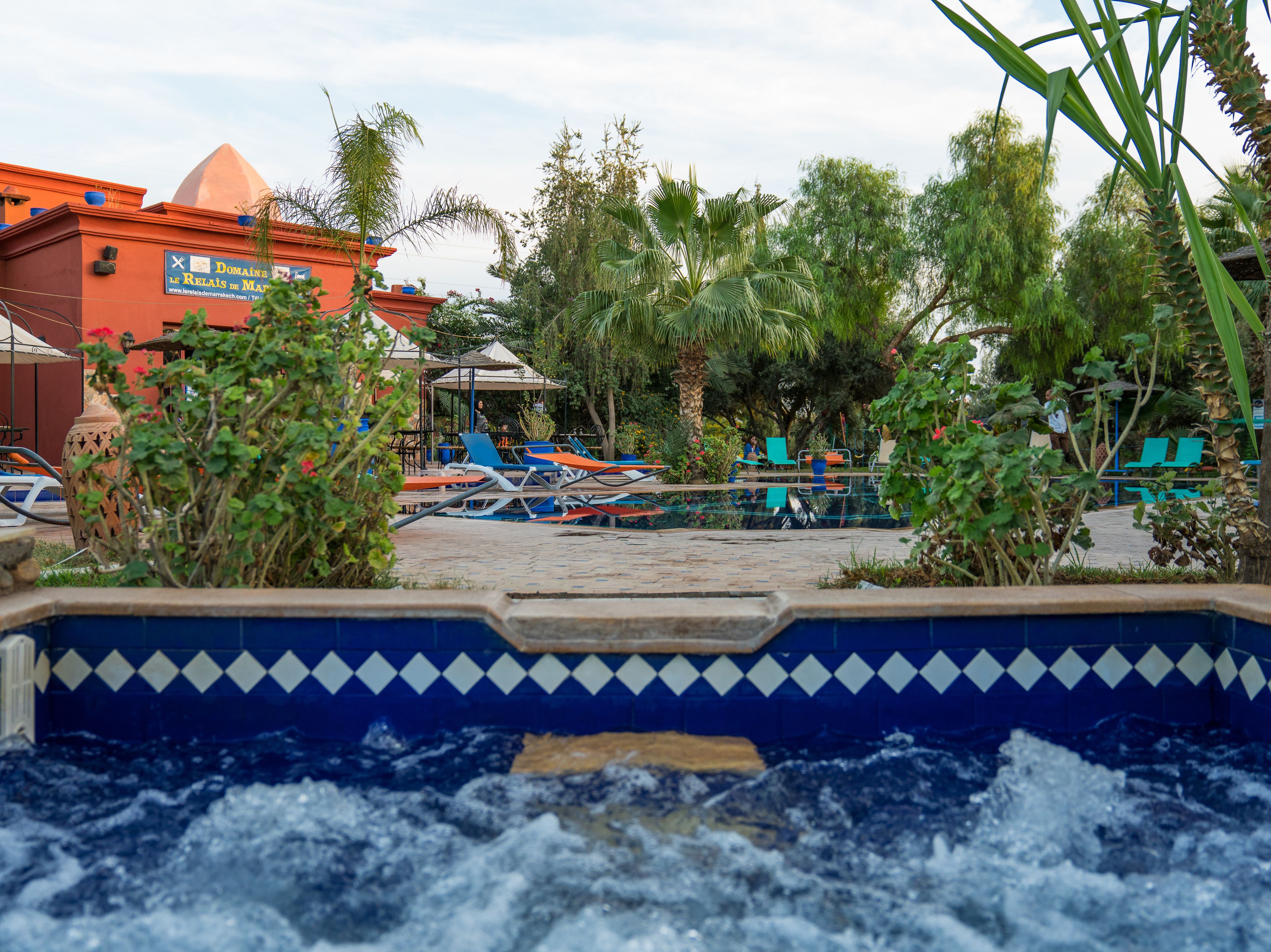 A pool area with lounge chairs and a water feature.