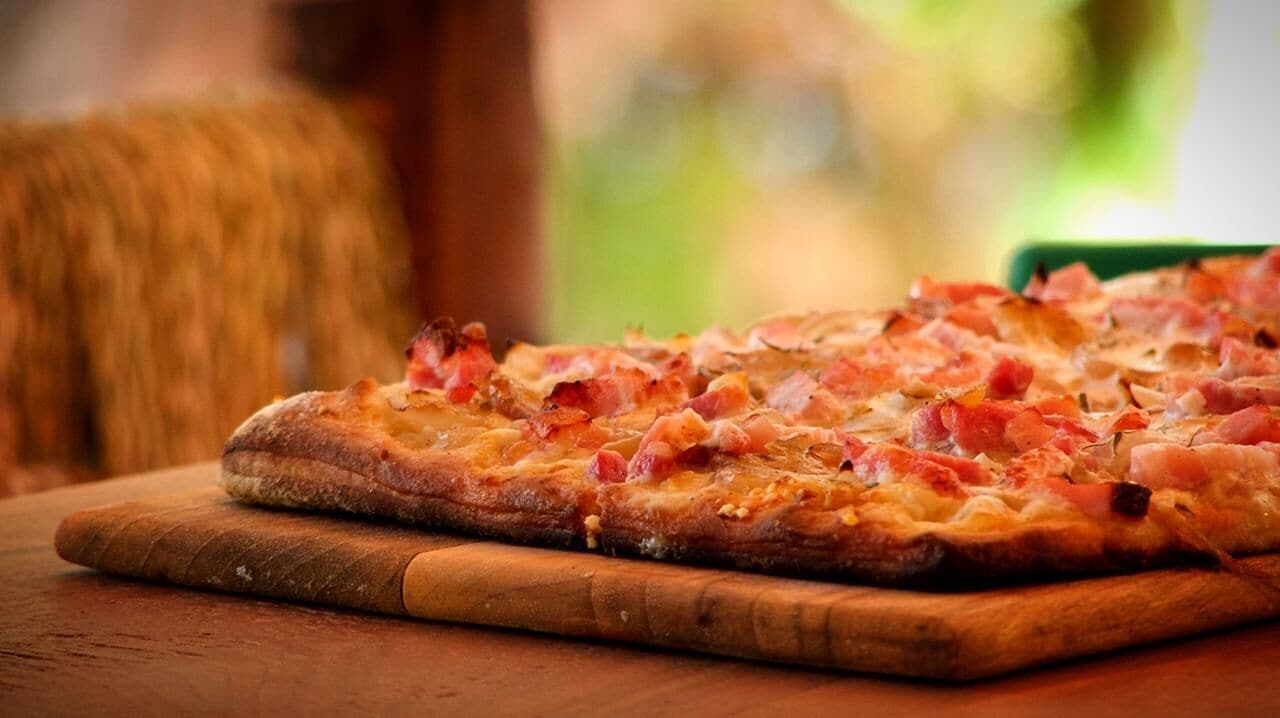 Eine Pizza auf einem Holzbrett.