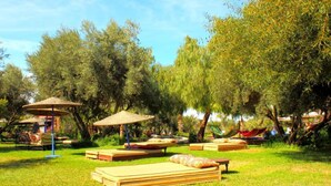 An outdoor relaxation area with sun loungers, a hammock, and a shaded seating area with umbrellas. - Le Relais De Marrakech (Marrakech)