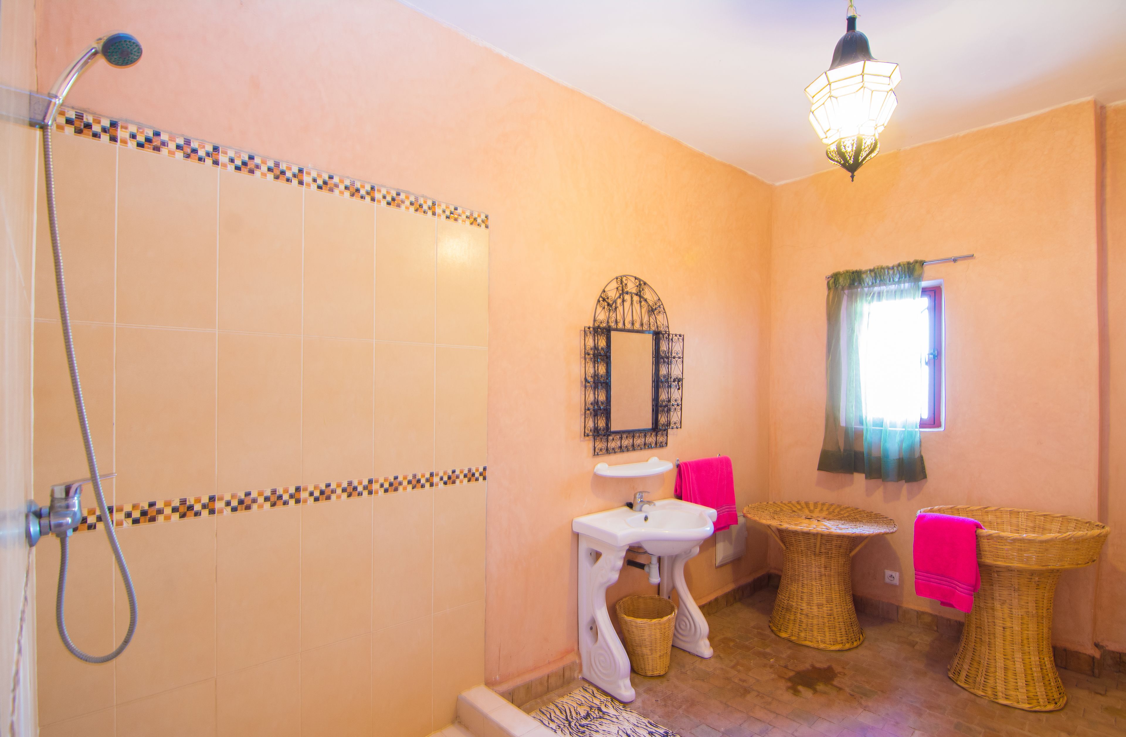 A bathroom with a shower, sink, and two bidets.