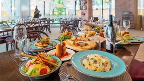A restaurant with multiple tables set for dining, featuring a variety of dishes and wine glasses. - Zornica Residence (Sunny Beach)