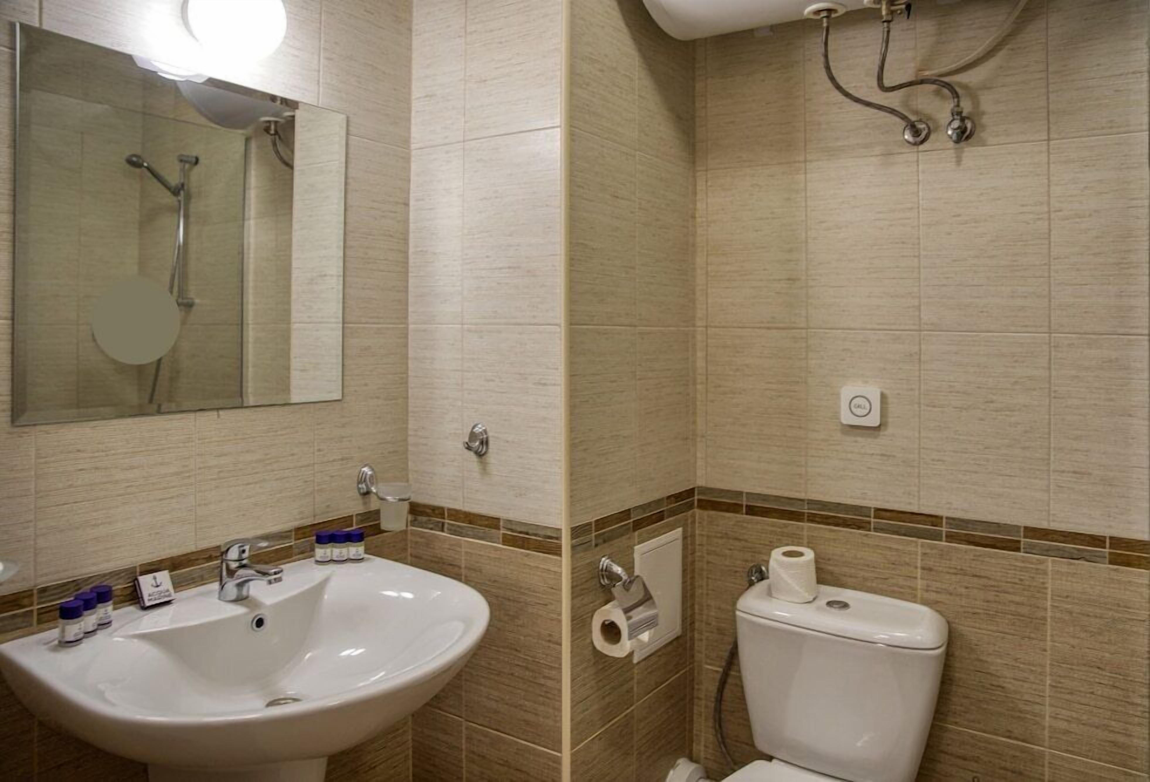 Une salle de bain équipée d’un lavabo, d’un miroir, de toilettes et d’une douche.