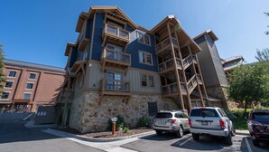 Un immeuble à plusieurs étages, doté d’une façade en pierre et de balcons en bois.
