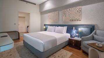 A modern bedroom with a large bed, bedside tables, a chair, and decorative wall panels.