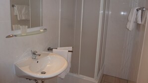A bathroom with a sink, mirror, and shower. - Pension Relax (Offenbach am Main)