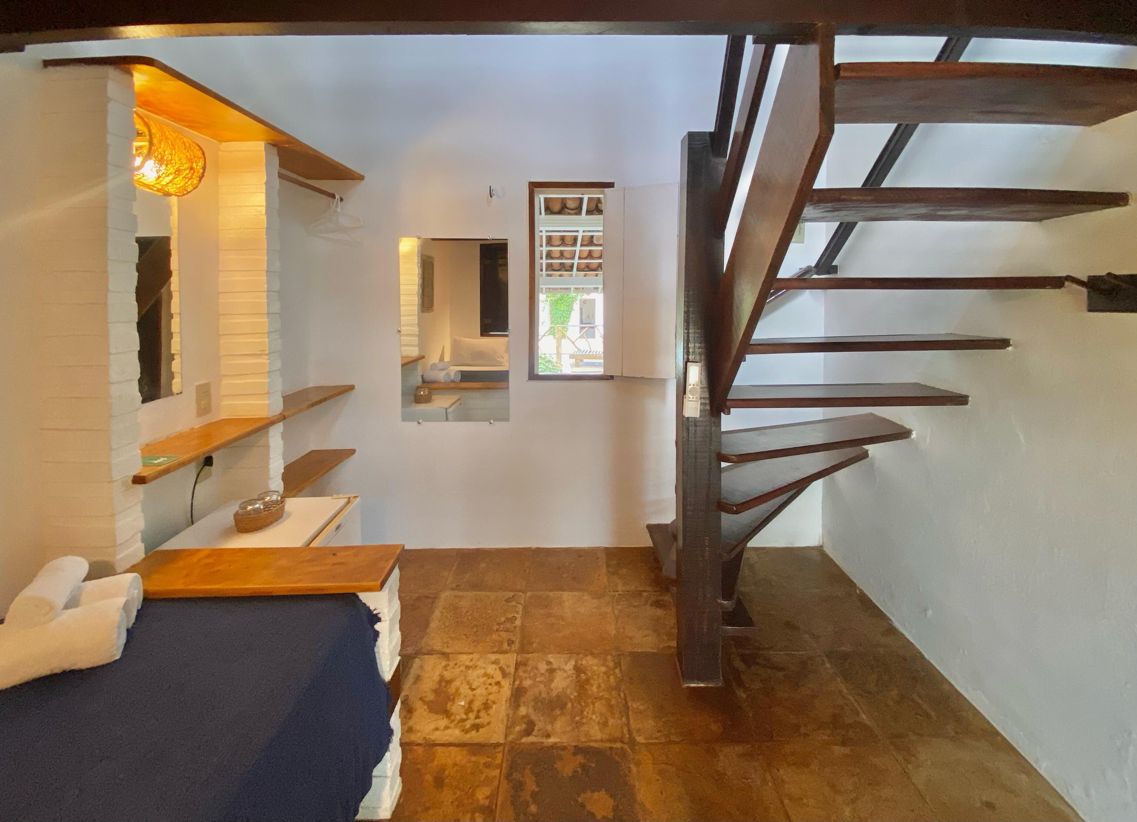 Una escalera conduce a un dormitorio con vistas al exterior.