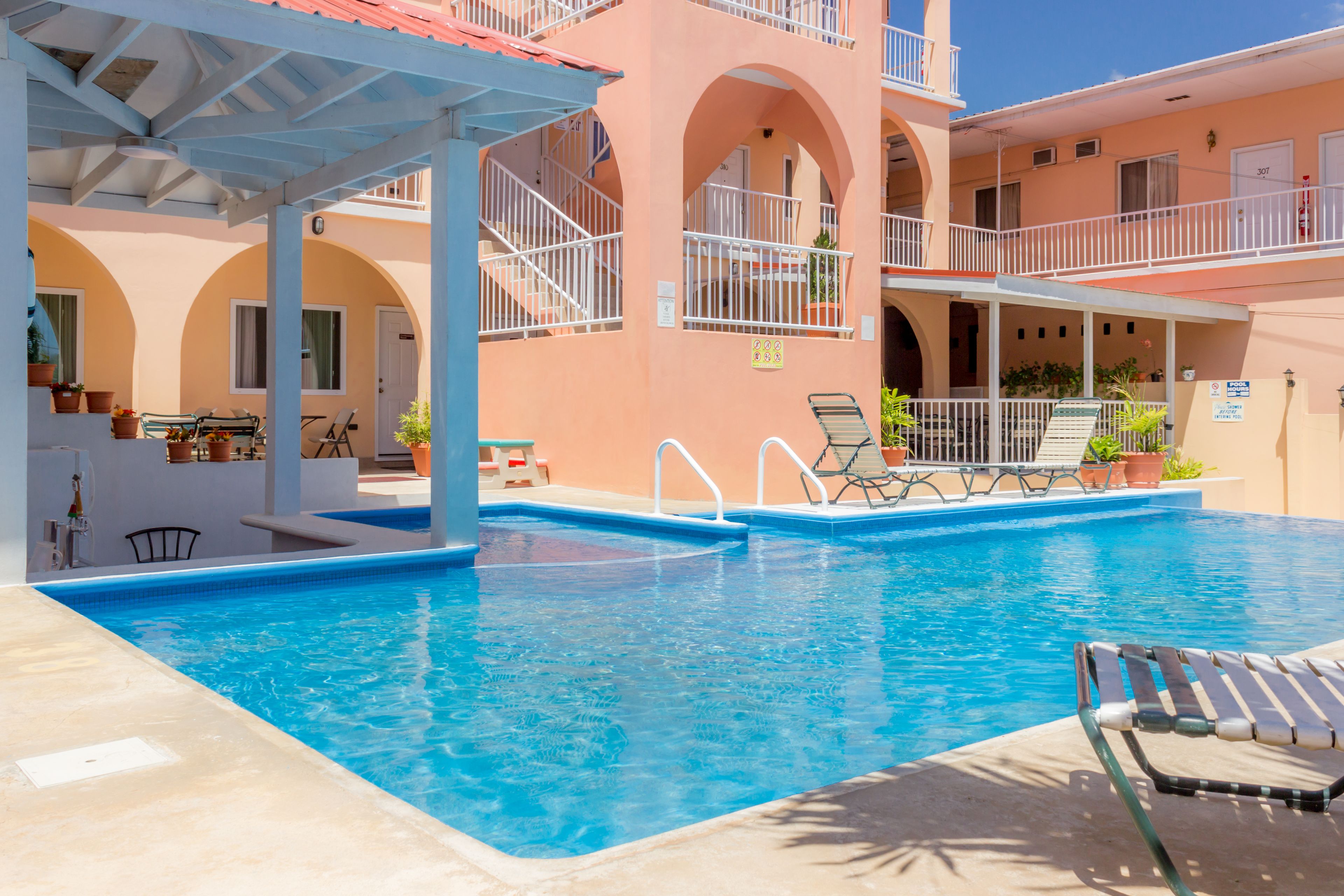 Un espace piscine avec des chaises longues et un coin salon abrité.