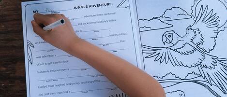 Una persona coloreando una página del libro 'Jungle Adventure'.