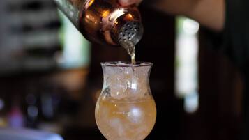 A bartender pouring a drink into a glass.