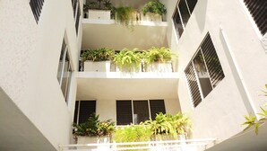 Un immeuble à plusieurs étages doté de balcons, chacun orné de plantes en pot.