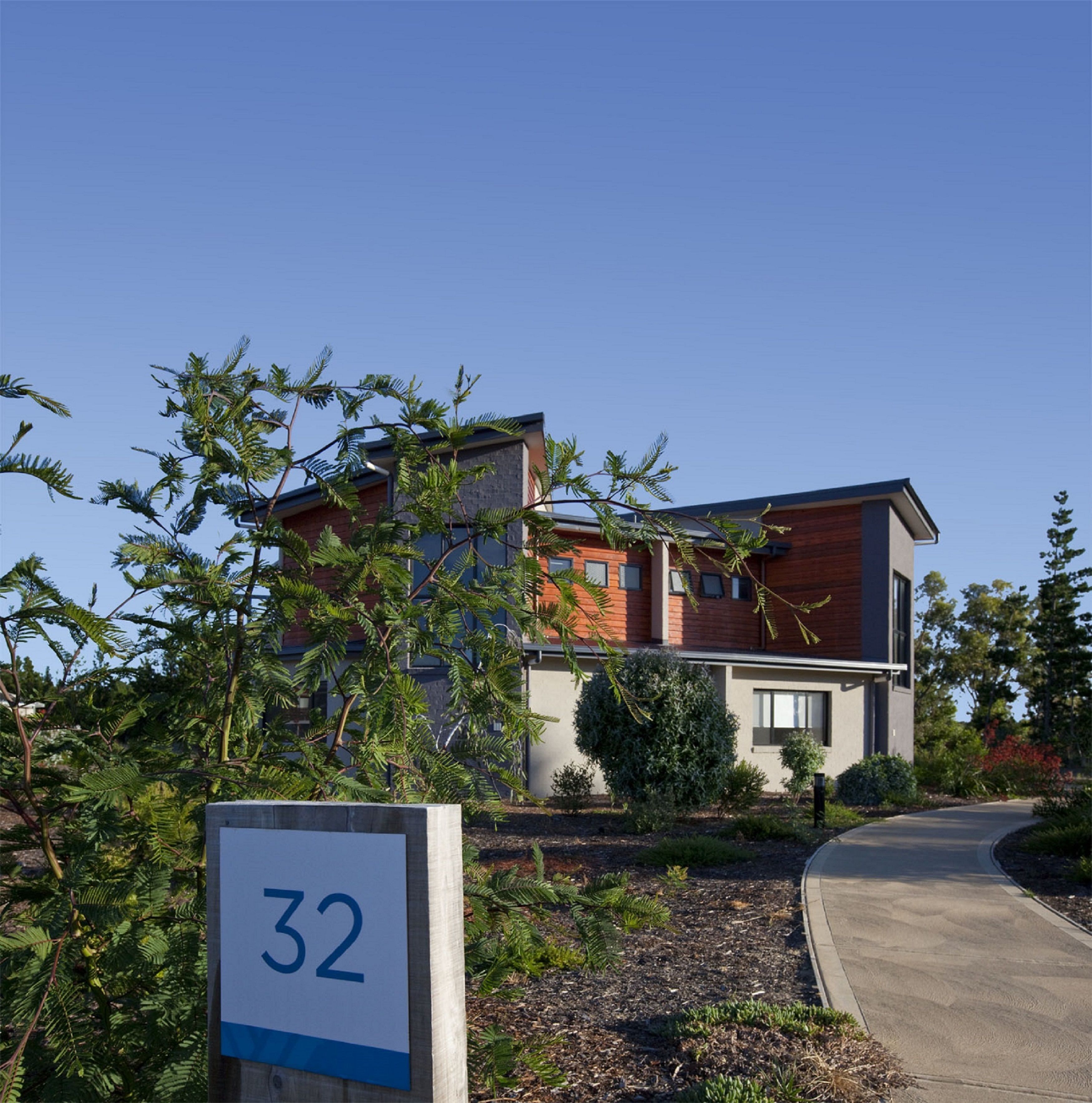 A modern two-story building with a sign indicating the number 32.