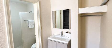 A bathroom with a shower, toilet, and sink.