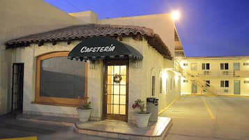 Enjoy a peaceful meal at this quaint cafeteria with a large window and decorative archway.