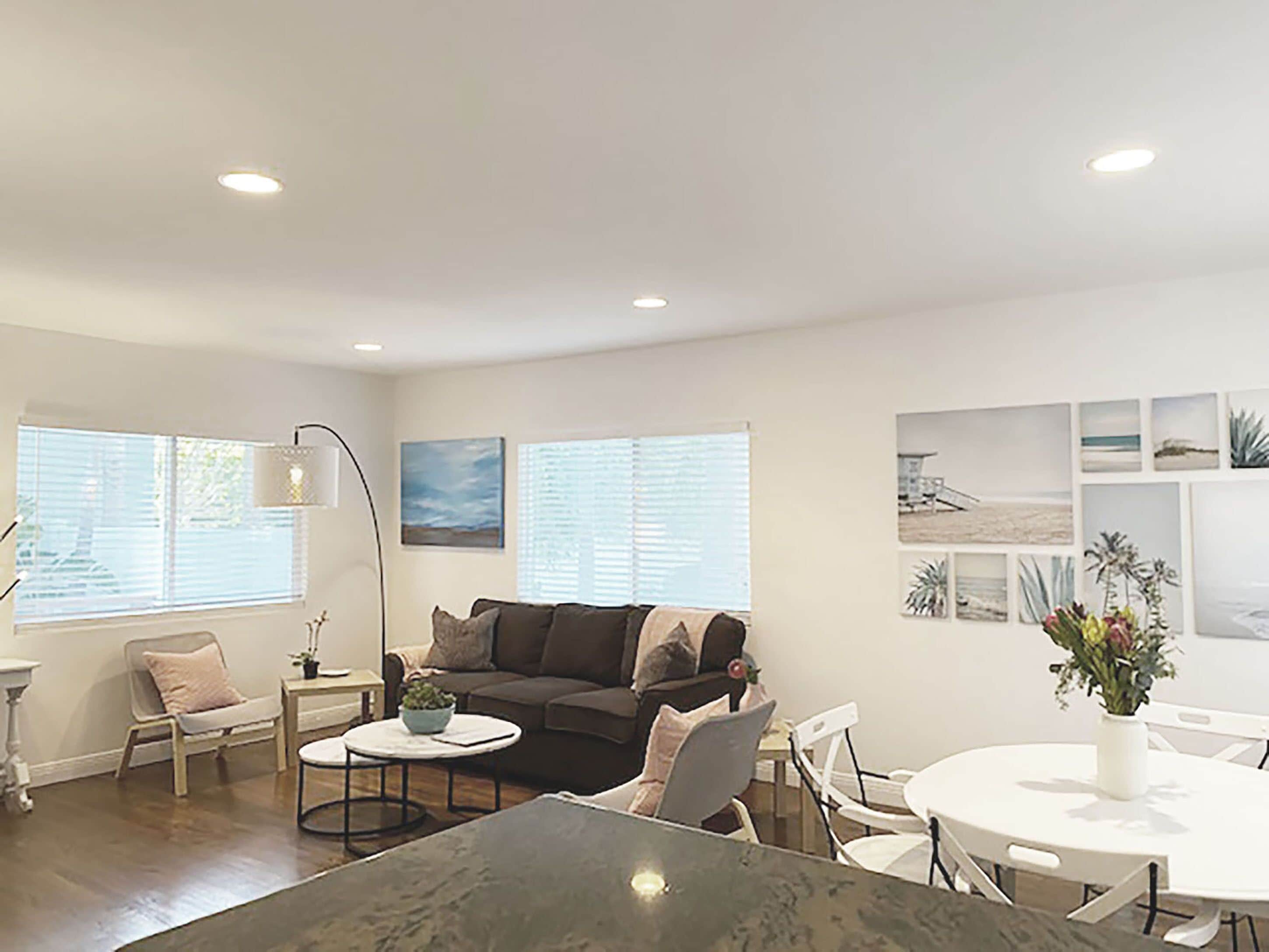 A modern living room with a sofa, coffee table, and dining table.