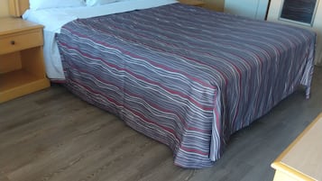 Habitación básica | Escritorio, tabla de planchar con plancha y ropa de cama