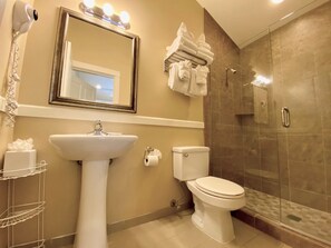 A bathroom with a sink, toilet, and a shower area.