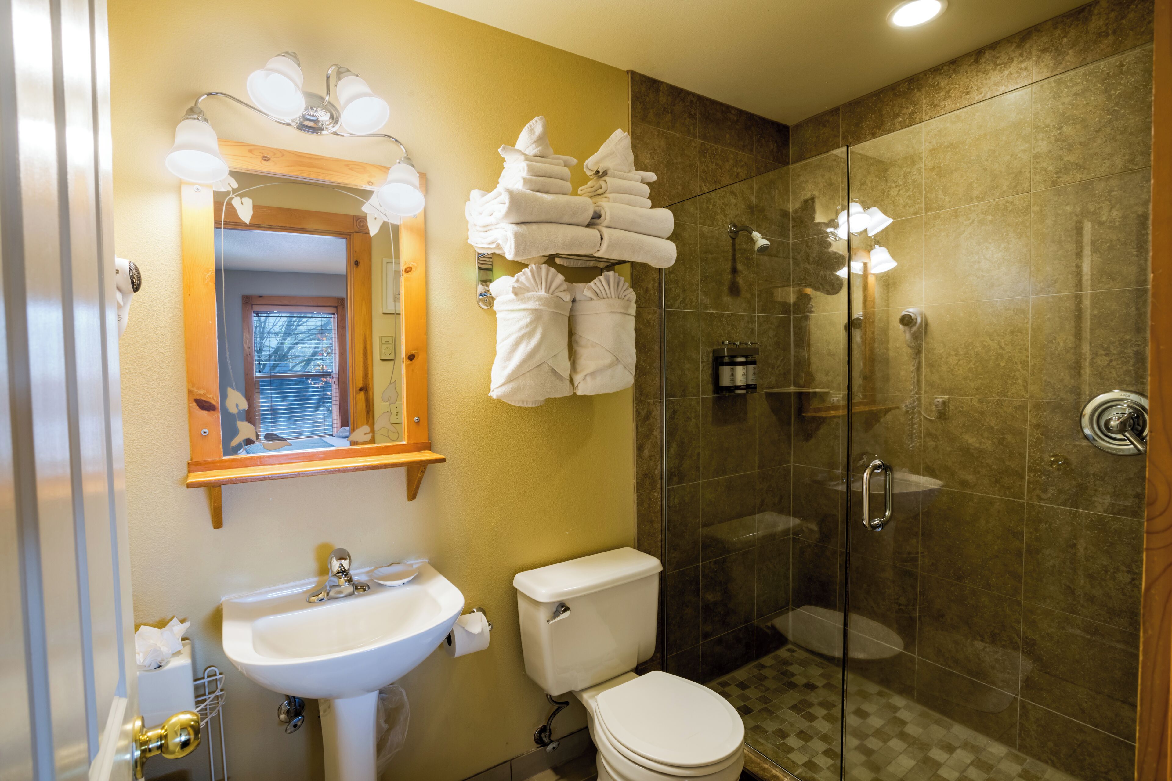 Un baño con lavamanos, inodoro y cabina de ducha de vidrio.