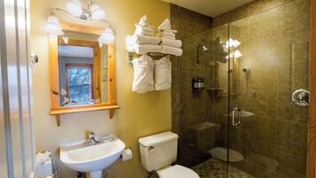 Un baño con lavamanos, inodoro y cabina de ducha de vidrio.