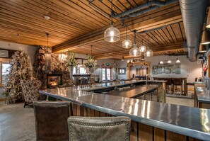 A spacious kitchen with a long island, hanging pendant lights, and a rustic wooden ceiling. - Bavarian Lodge (Leavenworth)