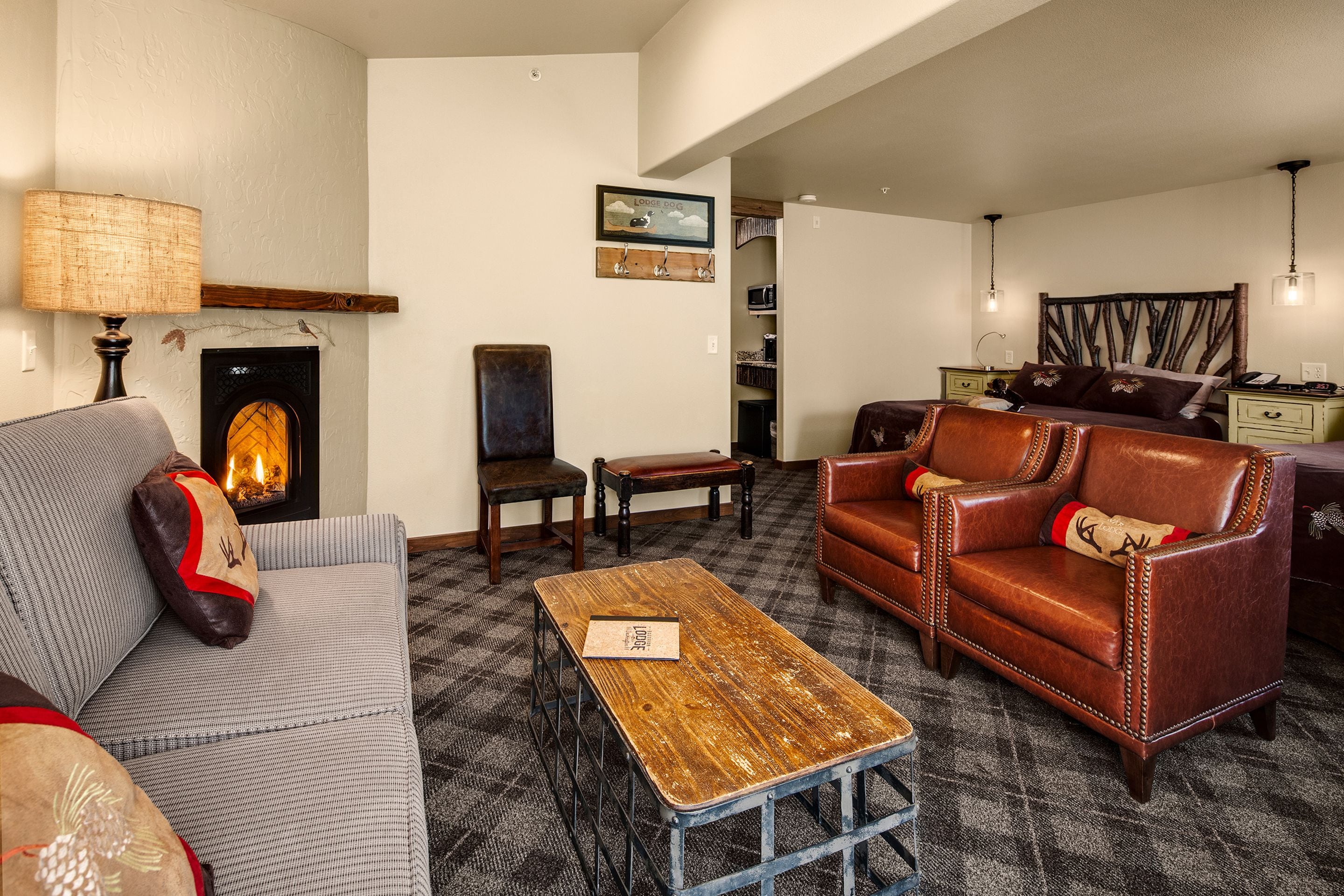 A cozy living room with a fireplace, leather sofa, and a wooden coffee table.