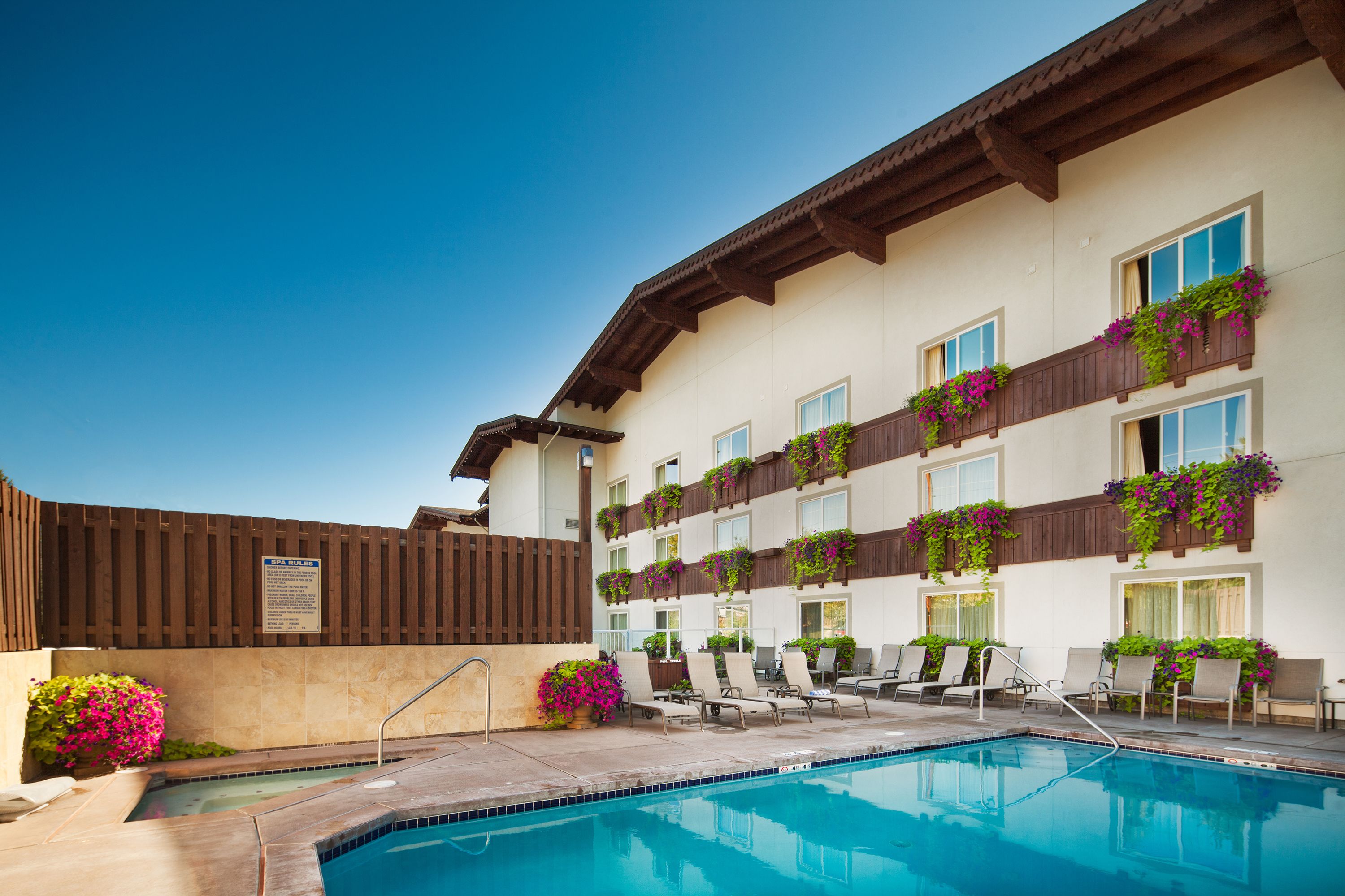 Una piscina al aire libre, sillones reclinables de piscina