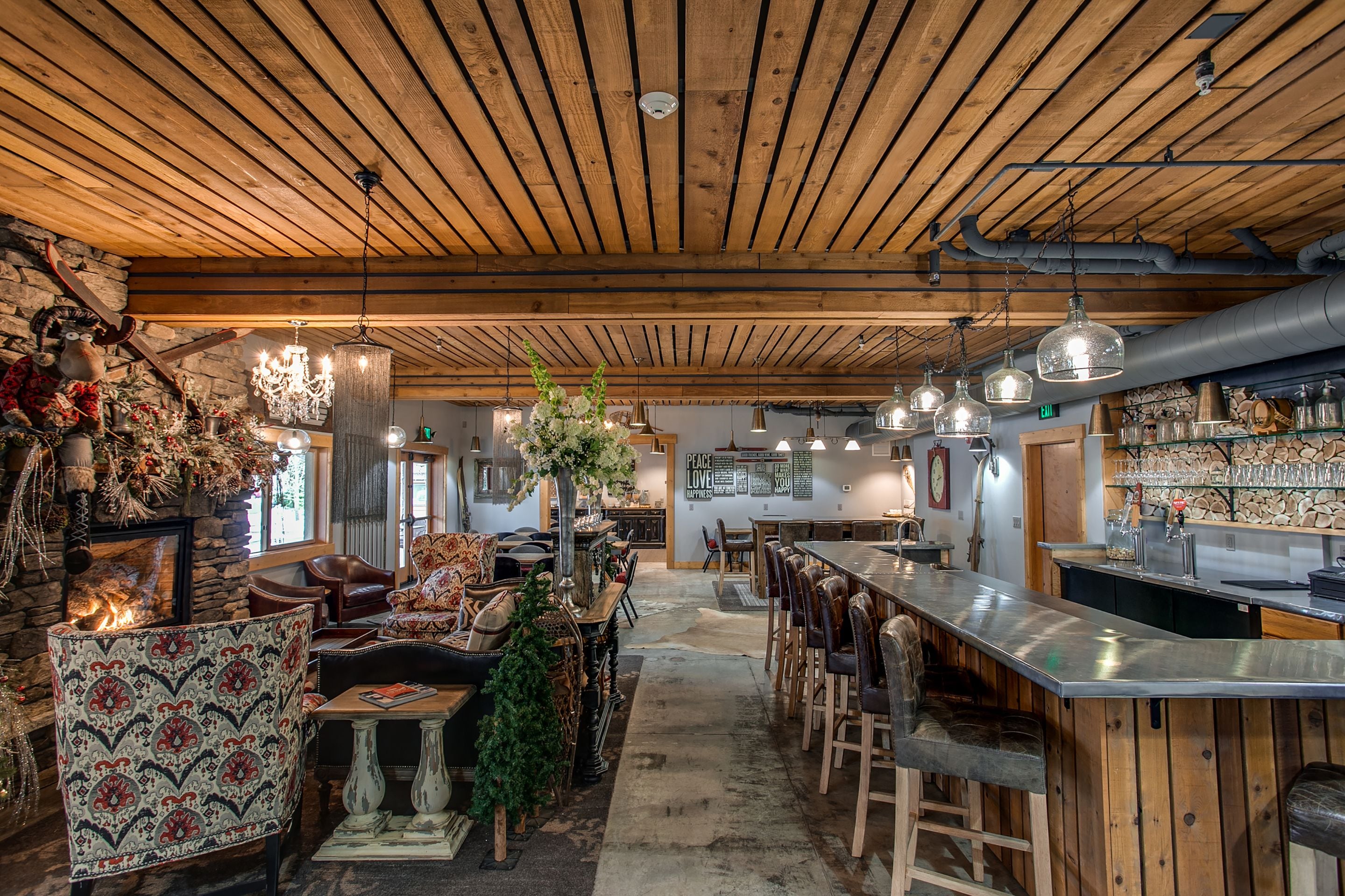 Ein rustikaler Innenraum mit Holzbalkendecke, einer Bar und Sitzgelegenheiten.