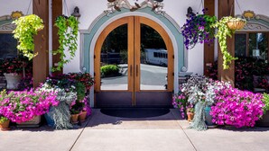 Un edificio tradicional con entrada de madera, un letrero atractivo y coloridos arreglos florales.