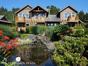 A lodge with a pond, wooden deck, and a cabin-like structure. - Inn at Cannon Beach (Cannon Beach)
