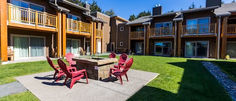 A courtyard with a fire pit, outdoor seating, and a pool.