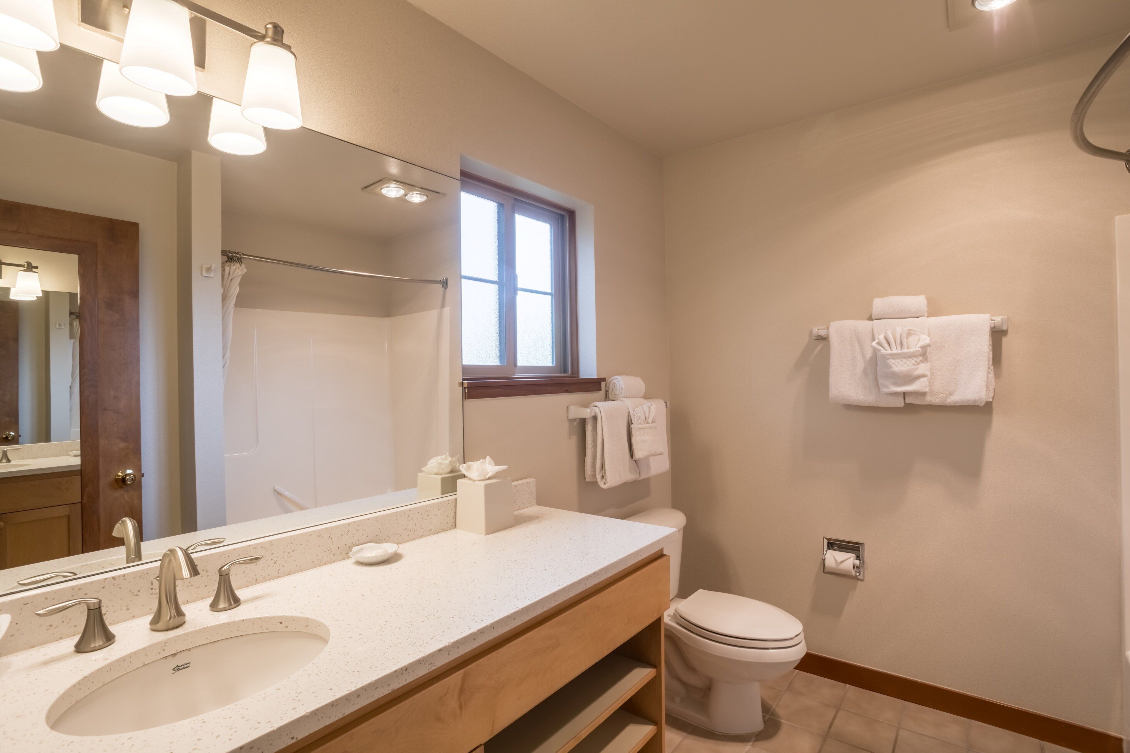 A bathroom with a sink, mirror, towel rack, and toilet.