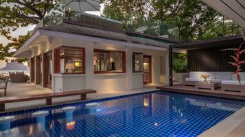 Una piscina al aire libre, sillones reclinables de piscina