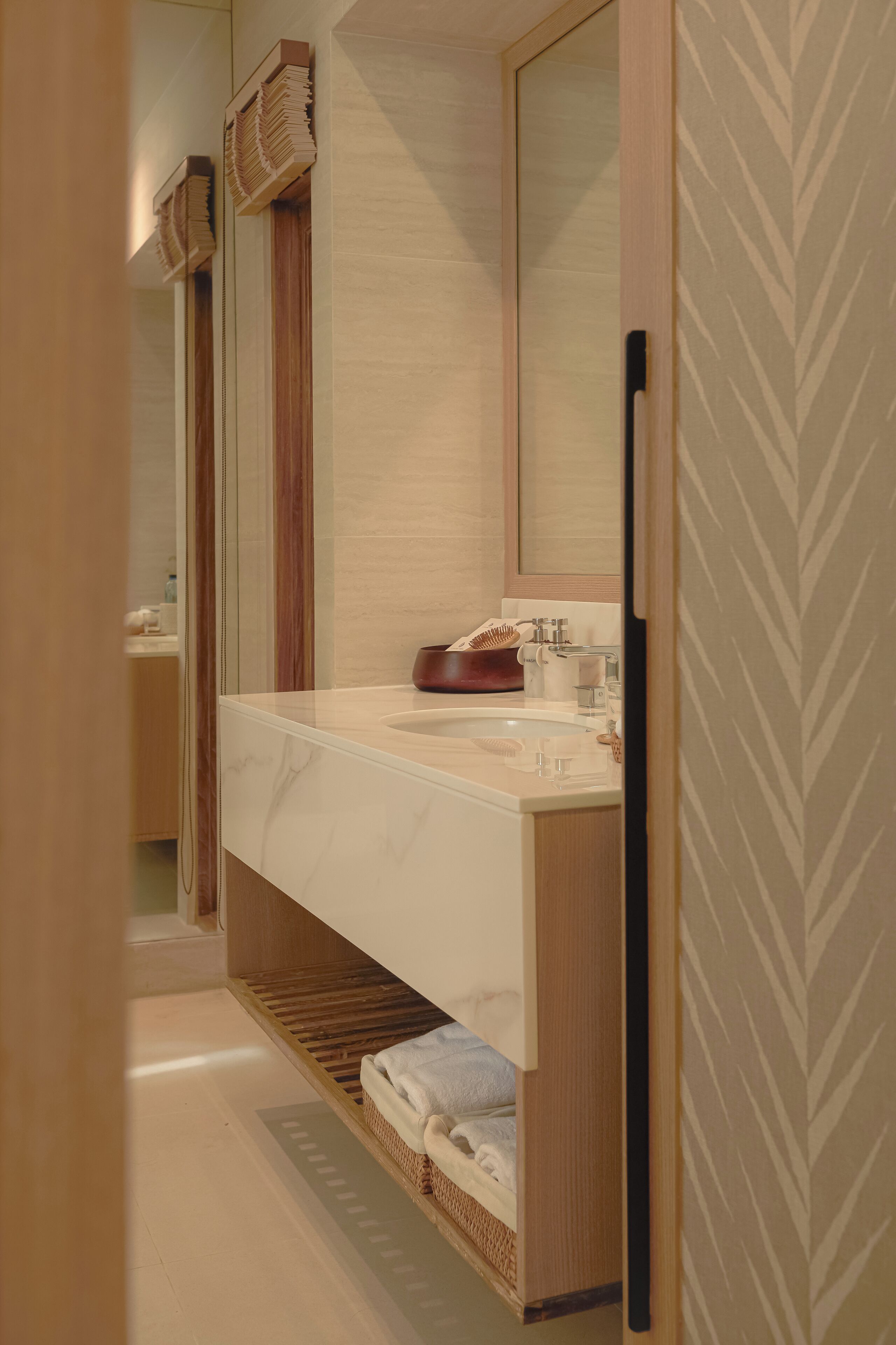 Une salle de bain moderne avec un grand miroir, un meuble-lavabo en bois et un porte-serviettes intégré.