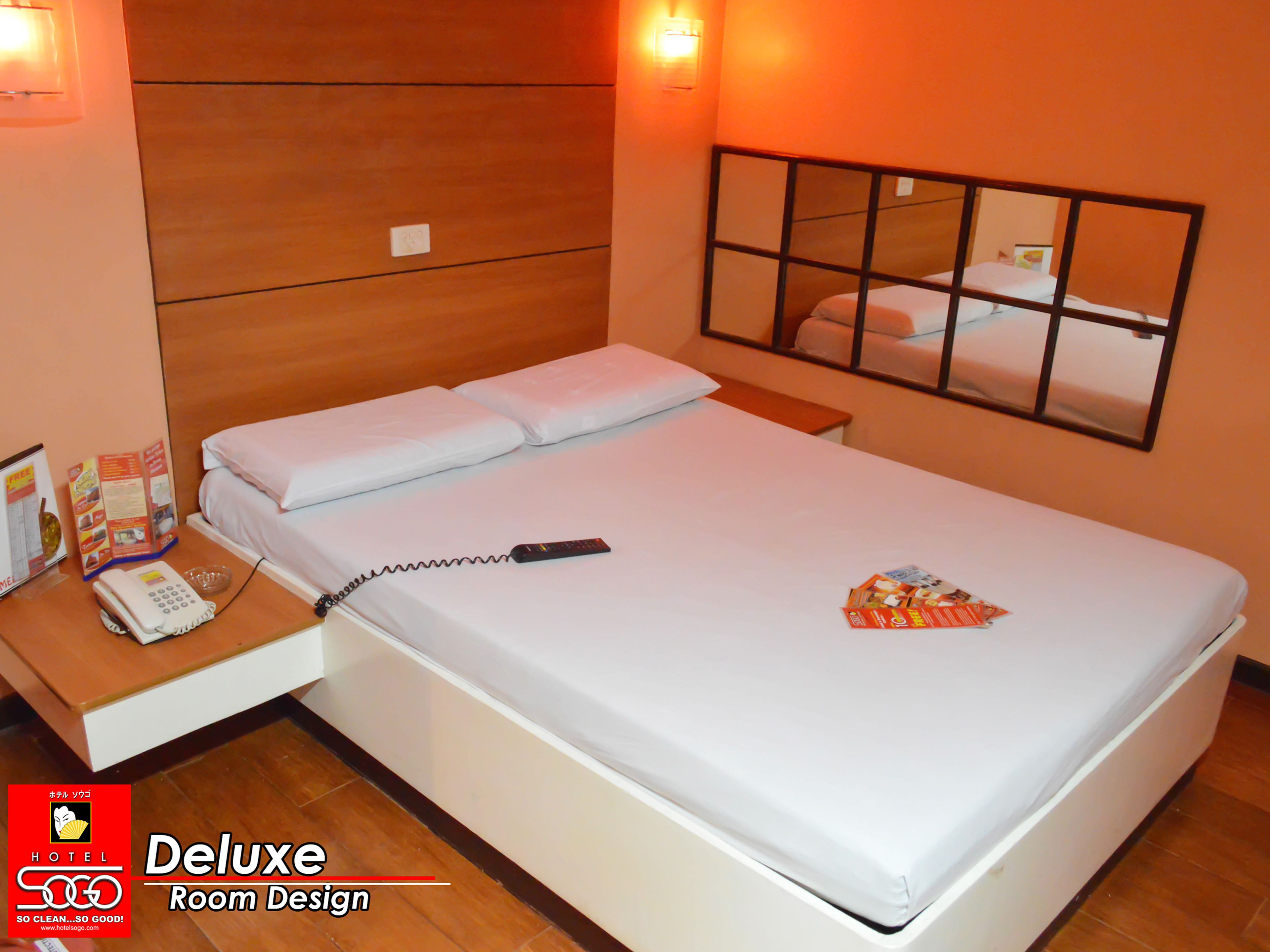 Una habitación de hotel de lujo con una cama grande, una mesita de noche y un espejo sobre la cama.