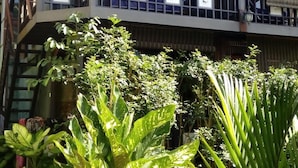 A two-story building with a balcony, surrounded by lush greenery and a small pond. - T Star Cottage (Langkawi)
